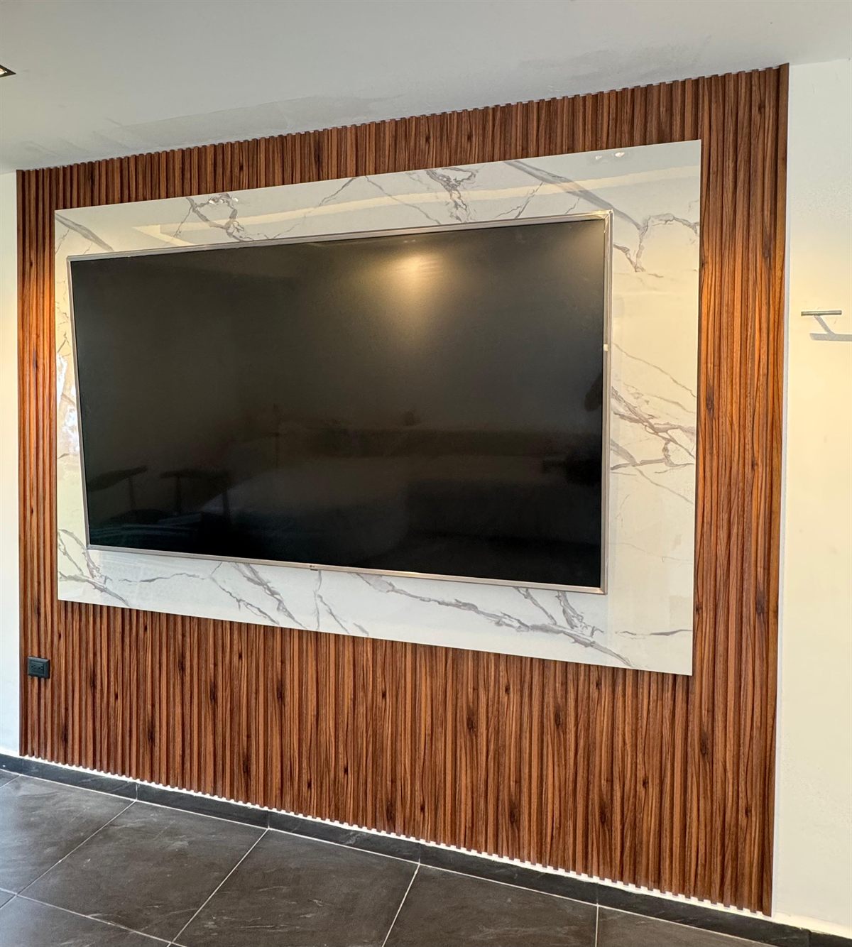 Mueble de TV a la medida con panel de madera y piedra tecnológica fabricado por Kahome Decoración